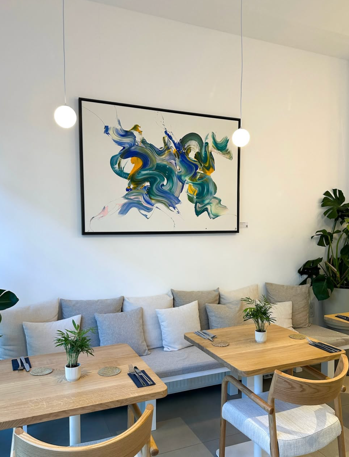 Großformatige abstrakte Malerei von Isabelle Breitkopf mit blau-grünen Farbbewegungen im Haileys Restaurant & Café