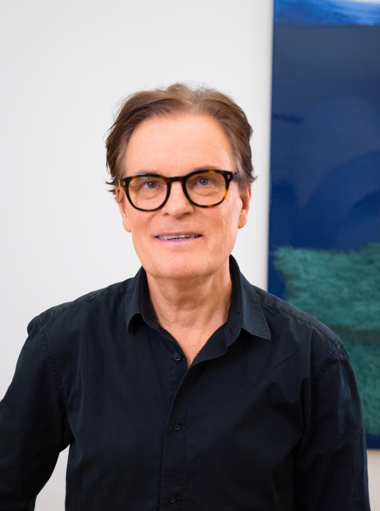 Portrait des Berliner Künstlers Harald Gnade vor zeitgenössischer Kunst zwischen Naturlandschaft und Abstraktion